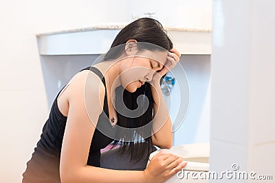 Asian woman with morning sickness,Pregnant female nausea into the toilet bowl Stock Photo