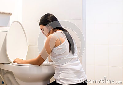 Asian woman with morning sickness,Pregnant female nausea into the toilet bowl Stock Photo