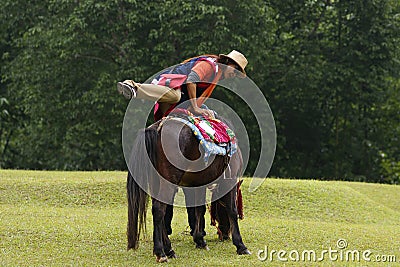 Asian woman mounting horse Stock Photo