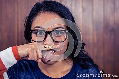 Asian woman with mustache on finger showing tongue Stock Photo