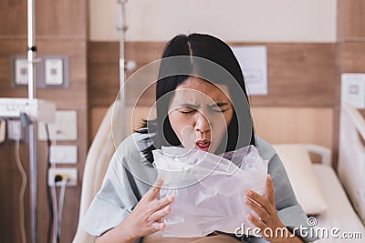 Asian woman patient puke or vomiting into plastic bag at hospital,Nausea,Indigestible Stock Photo