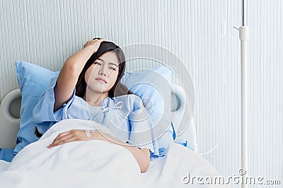woman patients Lying in a patient`s bed, having severe headaches Stock Photo
