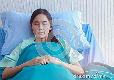 Asian woman patients sleep in bed Wait for the doctor to come to check Stock Photo