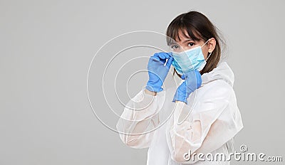 Asian woman puts on a protective mask and suit. Protected against flu, ebola, tuberculosis, virus. Stock Photo