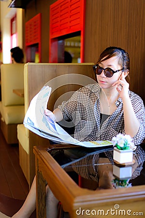 Asian woman reading newspaper Stock Photo