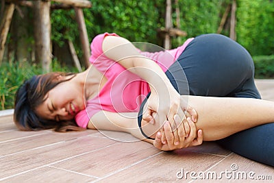 Asian woman runner laying on the floor and touching her injured Stock Photo