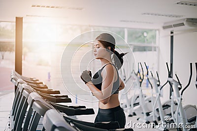 Asian women running sport shoes at the gym while a young caucasian woman is having jogging on the treadmill Stock Photo