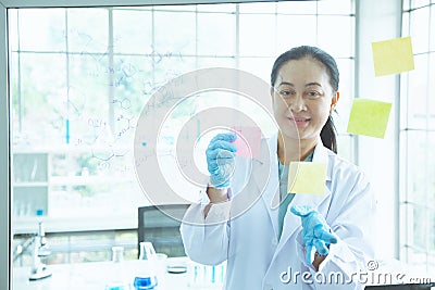 Asian woman scientist stick colorful short note on the board Stock Photo