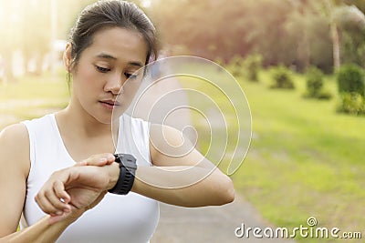 Asian Woman setting up the fitness smart watch for running. young women checking watch device. Women set smart watch before Stock Photo