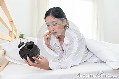 Asian woman shocked when wake up late by forget to setting alarm Stock Photo