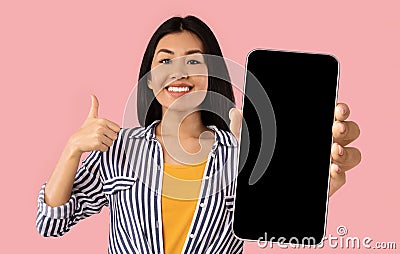 Asian woman showing empty smartphone screen and thumbs up Stock Photo