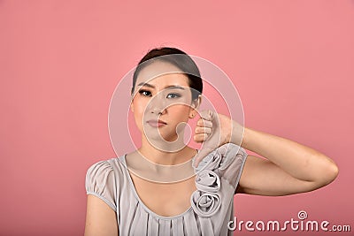 Asian woman showing thumb down gesture, Grumpy dissatisfied annoyed unhappy face expression Stock Photo