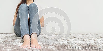 Asian woman sit on gray carpet floor with white cement textured background at the corner of house with copy space Stock Photo