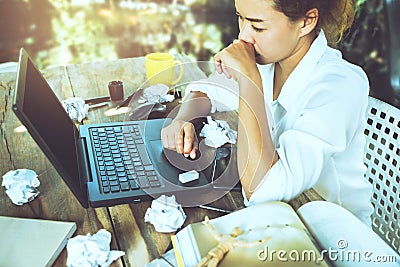 Asian woman sitting working at home on vacation. Use working with notebook. Feeling very stressed and headaches with work done Stock Photo