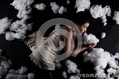 Asian Woman sleep on Scatter Fake Cloud at Night Sky Time Stock Photo