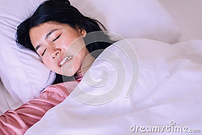 Asian woman sleeping and grinding teeth in bedroom,Female tiredness and stress Stock Photo