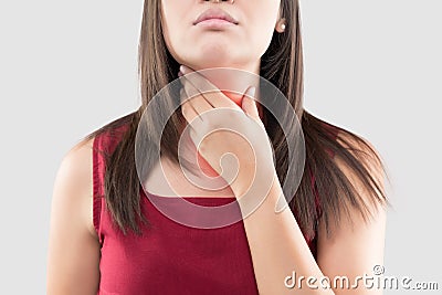 Asian woman with a sore throat or thyroid gland against the gray background. Acid reflux or Heartburn. Stock Photo