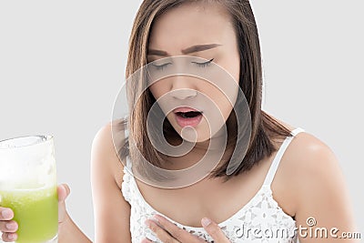 Asian woman is squeamish from the juice against gray background. Stock Photo