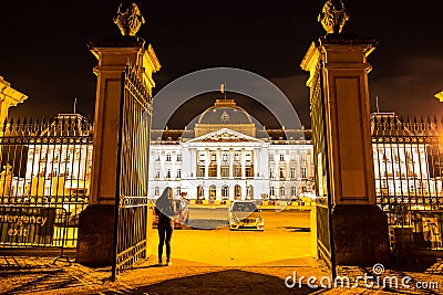 Asian woman standing in front of the gate of majestic Belgian Federal Parliament in the Palace of the Nation at night in Brussels Stock Photo