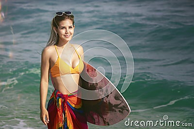Asian woman with surfboard on hand on the beach Stock Photo