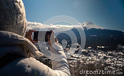 Asian woman take picture with smartphone to beautiful Fuji mountain at Japan Stock Photo