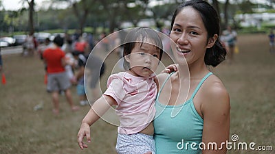 Asian woman and toddler participating in family games outdoor Stock Photo