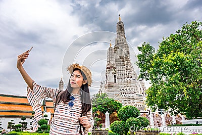 Asian woman tourist 20-30 years old with backpack is taking a photo or selfie with smartphone during a travel and relax in Stock Photo