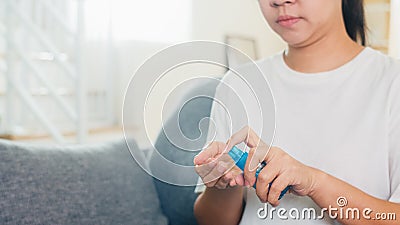 Asian woman using alcohol spray hand sanitizer wash hand for protect coronavirus. Female push alcohol bottle to clean hand for Stock Photo