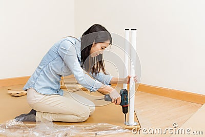 Asian woman using strew driver for assembling furniture Stock Photo