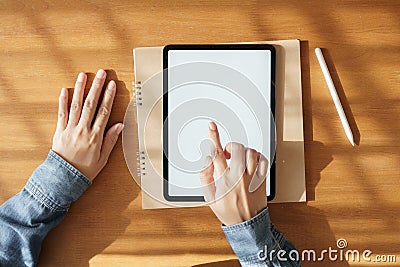 Asian woman using tablet with white screen on hand touchscreen technology item. it put on the desk and notebook Stock Photo