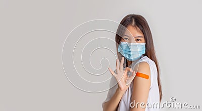 Asian woman wearing face mask with a smile on his face showing his vaccinated arm. vaccination, recommended inoculation concept Stock Photo