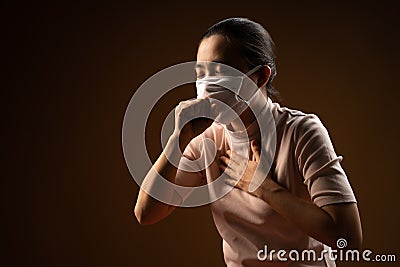 Asian woman wearing protective mask for protection from virus and disease coughing standing on beige background Stock Photo