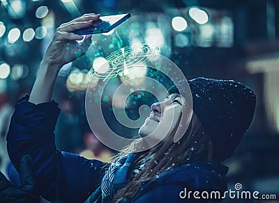 Woman in winter clothing is using Mobile phone for communication 3D technology Hologram futuristic panel Stock Photo