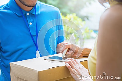 Asian woman accepting receive a delivery of boxes from delivery asian man Stock Photo
