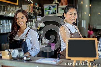 Asian women Barista smiling and using coffee machine in coffee s Stock Photo