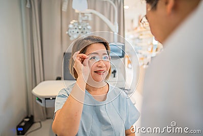 Client testing her new eyeglasses with optometrist in optical store Stock Photo