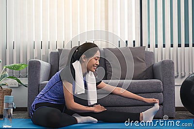 Asian women do stretching exercises after taking yoga classes while at home Stock Photo