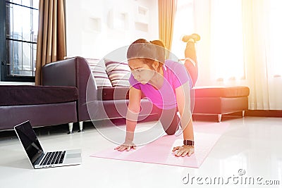 Asian women exercise doing arching back straightening leg up workout at home Stock Photo