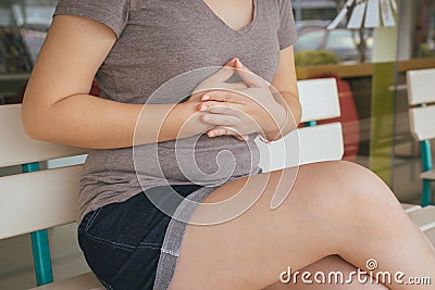 Asian woman having or symptomatic reflux acids,Gastroesophageal reflux disease,Because the esophageal sphincter that separates the Stock Photo