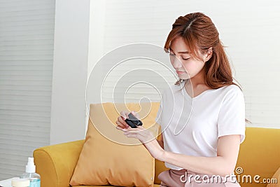 Asian women live at home Use a fingertip oxygen meter. Stock Photo