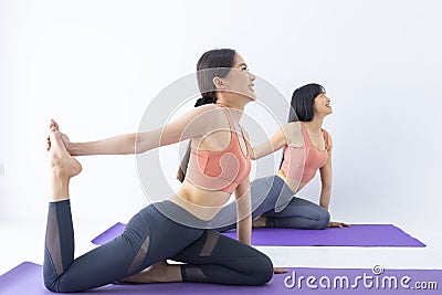 Asian woman practicing yoga indoor with easy and simple leg stretching position to control breathing in and out Stock Photo