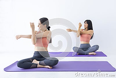 Asian woman practicing yoga indoor with easy and simple position to control breathing in and out in stretching arm posture Stock Photo
