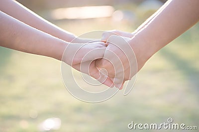 Asian women shaking hands in the warmth of the morning light. Stock Photo