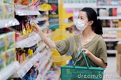 Asian women and surgical mask shopping some food in supermarket, covid-19 crisis Stock Photo