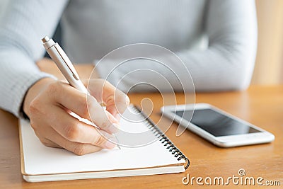 Asian women take notes with a pen in the office, business woman working on table Stock Photo