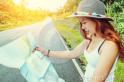 Asian women travel relax in the holiday. Take a look at the map on a rural road in the middle of nature. Thailand Stock Photo