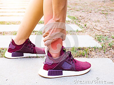 Asian women use hand touch and massage legs with ankle pain from outdoor exercise Stock Photo
