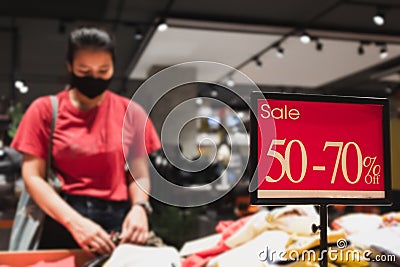 Asian women wear medical masks and buying discounted clothes Stock Photo
