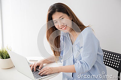 Asian women wearing casual dresses using computer laptop on desk at home, Concepts lifestyle and self study Stock Photo
