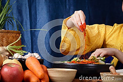Asian women wearing hanbok, a Korean national costume, cook traditional kimchi, fermented cooking. Stock Photo